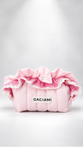 A pink quilted cosmetic pouch with ruffled trim, a bow, and a white label reading 'GACIAMI' on a light gray background.