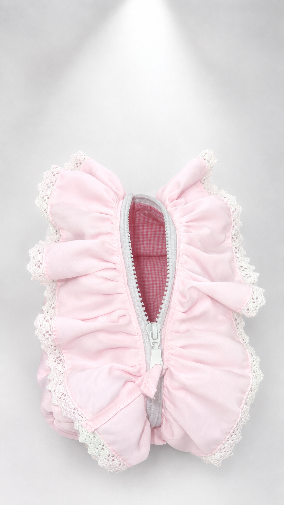 A light pink ruffled zippered pouch with white lace trim, shown from a top-down view on a light gray background.
