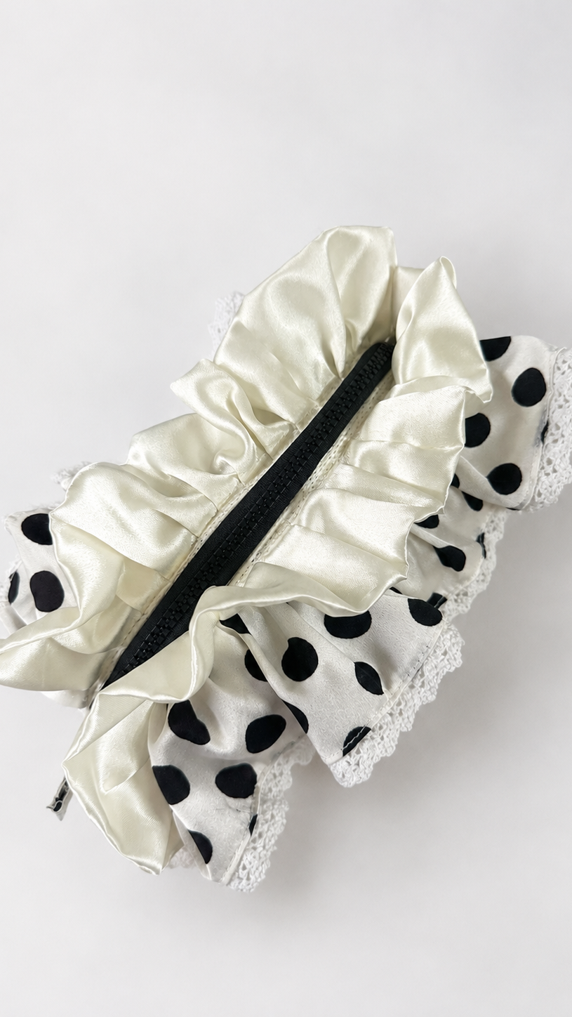A white satin ruffled garter belt with black polka-dot trim and white lace edges, displayed on a clean white background.
